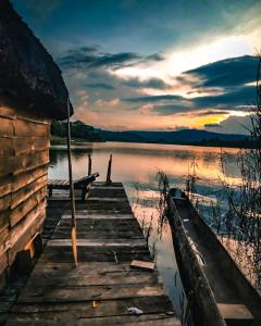 a wooden dock on a lake with a sunset at Paradise Eco-Hub in Kabale