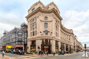 Arcore Premium Apartments: Mayfair في لندن: مبنى كبير يوجد امامه ساعه