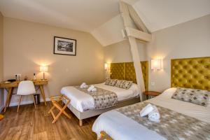a room with two beds and a cross on the wall at Hotel Restaurant La Verperie in Sarlat-la-Canéda