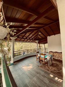un porche con mesa, sillas y un puente en The beach gate villa en Beruwala