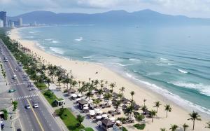 an aerial view of a beach with palm trees at Sofiana My Khe Hotel & Spa- Rooftop Pool Bar in Danang