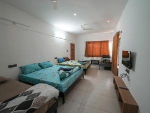 uma sala de estar com duas camas e uma televisão em Silver springs Homestay Chickmagalur em Chikmagalur