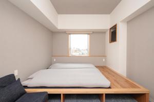OTHER SPACE Asakusa في طوكيو: غرفة نوم بسرير واريكة