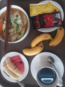 einen Tisch mit Teller mit Lebensmitteln und Schüsseln mit Lebensmitteln in der Unterkunft Vang Vieng Chanthala Hotel 1 in Vang Vieng