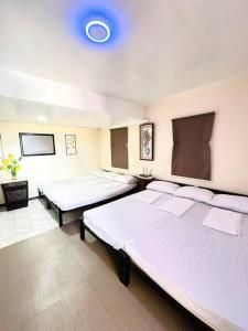 um quarto com duas camas e um tecto azul em Transient House Camarines Sur Pili em Pili
