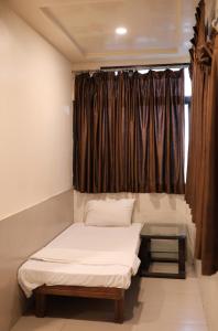 a room with two beds in front of a window at Al Zam Zam in Nagpur