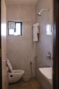 a bathroom with a toilet and a sink and a tub at Al Zam Zam in Nagpur