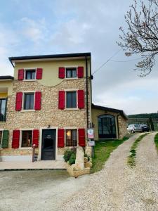 a large brick house with red shuttered windows at Agriturismo Tamellini in Soave