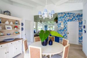ein Esszimmer mit einem weißen Tisch und einer Topfpflanze in der Unterkunft 4 BR Villa on Seventh Hole in La Romana