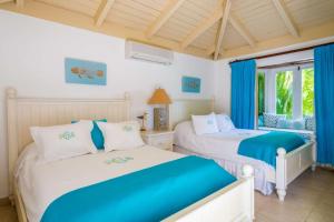 2 Betten in einem Schlafzimmer mit blauen Vorhängen in der Unterkunft 4 BR Villa on Seventh Hole in La Romana