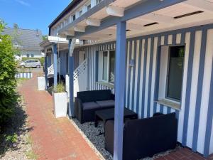 a porch of a house with blue and white stripes at Vordeck FW 1 in Zingst