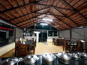 een restaurant met tafels en stoelen met potten en pannen bij Silver springs Homestay Chickmagalur in Chikmagalūr
