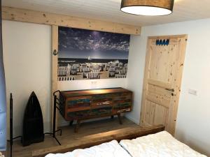a bedroom with a dresser and a painting on the wall at Vordeck FW 1 in Zingst
