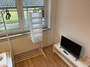 a room with a flat screen tv and a shelf with a television at Bavaria Home - Küche, Terrasse, 3 Schlafzimmer in Mainburg