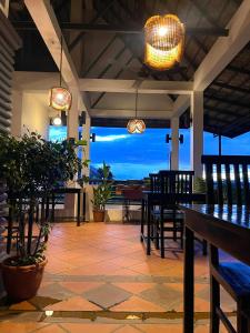 a patio with tables and chairs and a view of the ocean at Sunset View Guest House in Siem Reap