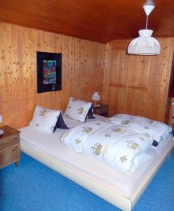 een slaapkamer met een groot wit bed en houten wanden bij Ferienhaus La Valletta in Rueras