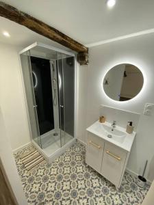 La salle de bains est pourvue d'une douche, d'un lavabo et d'un miroir. dans l'établissement Maison village rénovée tout équipée, à Saix