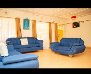 sala de estar con 2 sofás azules en Airport View Homes en Eldoret