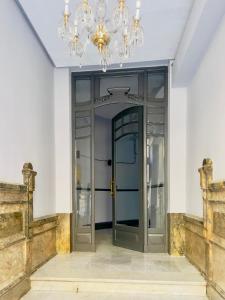 un couloir avec une porte en verre et un lustre dans l'établissement Varillas Luxury Home I y II, à León
