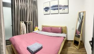 Homestay M-Latino Dalat في Da Thien: غرفة نوم مع سرير وردي ومرآة