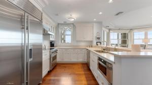 a kitchen with white cabinets and a stainless steel refrigerator at Residence 703 At The Grand in Wildwood