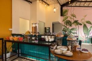 a restaurant with a counter with dishes on it at Olive Hotel Electronic City by Embassy Group in Bengaluru