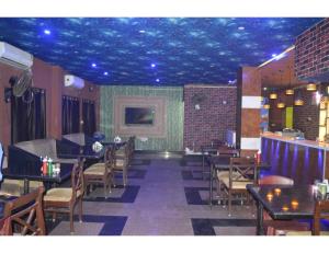 uma sala de jantar com mesas e cadeiras e um tecto azul em Hotel Aadhar, Barbil, Odisha em Bada Barabīl