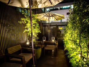 a patio with a table and an umbrella at Glansit Kyoto Kawaramachi in Kyoto