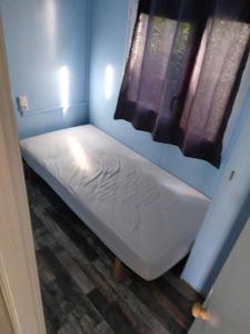 - un petit lit dans une chambre avec fenêtre dans l'établissement Mobile home Portiragnes, à Portiragnes