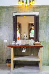 ein Bad mit einem Waschbecken und einem Spiegel in der Unterkunft Blue Beach Village Homestay in Hoi An