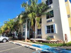 un edificio con palmeras frente a un aparcamiento en Kodesh Vacation Club Combate, Cabo Rojo, en El Combate