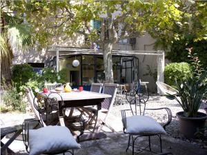 een patio met een tafel en stoelen in een tuin bij Bord de mer, magnifique appartement de 150m2 avec jardin in Marseille