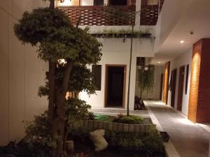 a house with a tree in the middle of a courtyard at Urbanview Hotel Nardis Living in Ngabean