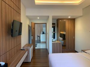 a hotel room with a bed and a tv at Urbanview Hotel Nardis Living near UMY in Ngabean