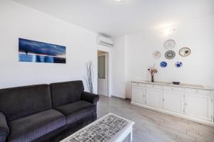 uma sala de estar com um sofá e uma mesa em Casa al Ponte dei Marmi - few KM to sea - Happy Rentals em Seravezza