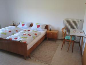 1 dormitorio con 1 cama y 1 mesa con silla en Gasthaus Hingerl en Obing