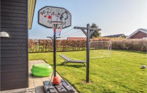 a basketball hoop in a yard with a chair at Holiday Home Råde Strandpark Vi in Årøsund