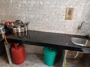 a kitchen with a counter with a sink and a counter at Hotel Charaksanjivani in Navi Mumbai