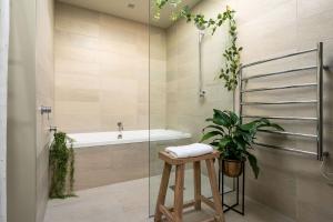 a bathroom with a bath tub and a stool with a plant at Dunedin Central Luxe Pad in Dunedin +41 photos