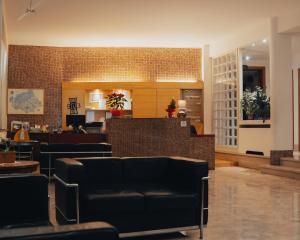 un hall avec des canapés noirs et un bar dans l'établissement Hotel all'Oasi, à Paese