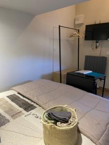 Una habitación con una cama con una cesta. en Chambre Folle Avoine, en Brié-et-Angonnes