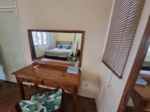 een slaapkamer met een spiegel en een bureau met een bed bij Cutty Sark Lodge in Kariba