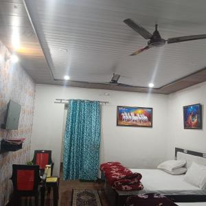 Camera con letto e ventilatore a soffitto. di Somnath Residency a Vrindāvan