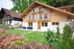 a large wooden house with a lawn in front of it at Lakeview Family Apartment in Ringgenberg