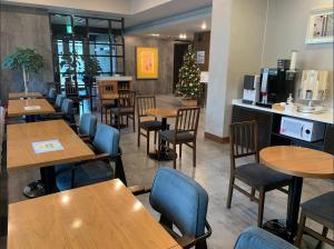a restaurant with tables and chairs and a christmas tree at I-check Hyunjin Hotel in Donghae