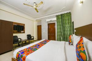 sypialnia z dużym łóżkiem i wentylatorem sufitowym w obiekcie FabExpress Smart Stay w Nowym Delhi
