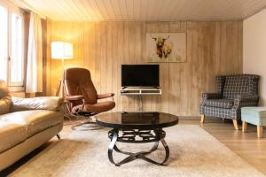 un soggiorno con divano e tavolo di Lakeview Family Apartment a Ringgenberg