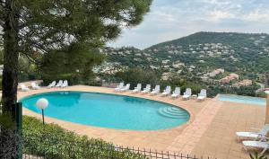 einen Pool mit Liegestühlen und Aussicht in der Unterkunft Loucasa in Roquebrune-sur-Argens