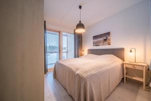 a bedroom with a bed and a large window at Levillas Tunturinlaita D5 in Levi