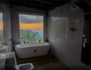 a bathroom with a bath tub and a large window at Ro Yo Rock Ella in Ella